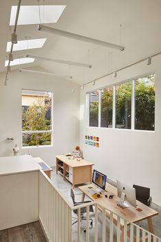 an office with white walls and wooden floors