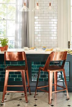 two wooden chairs sitting next to each other in front of a table with plates on it