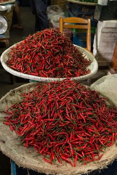 two bowls filled with red peppers on top of a table