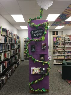 a purple book tower with books on it in a library