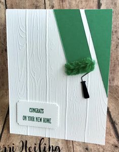 a white card with green trim and a black tassel on the corner, that says congrats on your new home