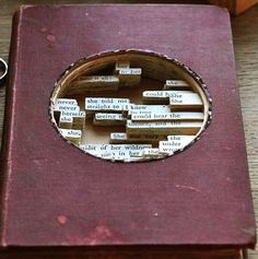 an open book sitting on top of a wooden table next to a pair of scissors