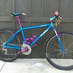 a blue and purple bike parked in front of a building