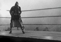 a man standing on top of a boxing ring