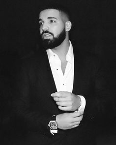 a man with a beard wearing a suit and watch