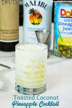 toasted coconut pineapple cocktail in a tall glass with the ingredients on the side