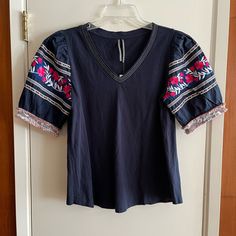 Size Small Nwt Anthropologie Embroidered Top. Sleeves Have Embroidered Details. Spring Short Sleeve Tops With Contrast Embroidery, Spring Tops With Contrast Embroidery And Short Sleeves, Short Sleeve Tops With Contrast Embroidery For Spring, Navy Embroidered Cotton Tops, Blue Cotton Embroidered V-neck Top, Blue Cotton Top With Embroidered Hem, Blue Cotton Top With Embroidered Sleeves, Blue Cotton Embroidered Hem Top, Blue Cotton Embroidered Top With Embroidered Hem