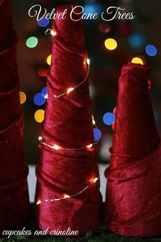 three red cones with lights on them are in front of a christmas tree and the words velvet cone trees