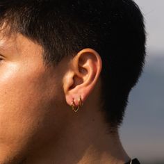 a close up of a person with ear piercings on their ears and wearing a black shirt