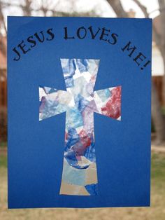 a cross made out of tissue paper with the words jesus loves me