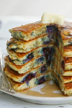 a stack of pancakes with blueberries and butter on top