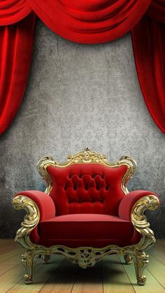 a red chair sitting in front of a curtain