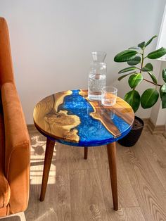 a table with a glass vase sitting on top of it next to an orange chair