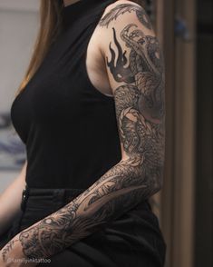 a woman with a dragon tattoo on her arm and shoulder is posing for the camera