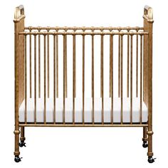 a wooden crib with white sheets on the bottom and sides, in front of a white background