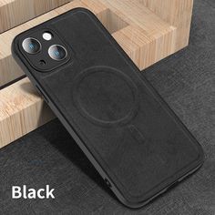 an iphone case sitting on top of a wooden table next to a black phone holder