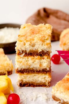 three pieces of cake sitting on top of a table next to other desserts and fruit