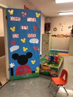 a door decorated with mickey mouse and other items in a room that is filled with children's toys