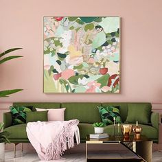 a living room with pink walls, green couches and a painting on the wall