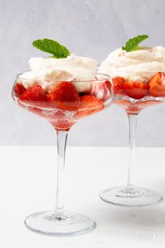 two glasses filled with strawberries and whipped cream