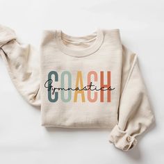 Gymnastics Coach Sweatshirt, Gymnastics Coach Shirt, Gymnastics Coach Gift, Gymnast Coach Crewneck Sweatshirt Unisex How to Order 1* View all color and size charts before you place your order. 2* Select your shirt "SIZE" and "COLOR". 3* Click add to cart.  If you are ordering more than 1 item, you need to repeat this process for each item you wish to order. Product Information Gildan Hoodie- Sweatshirt 8 oz.(US) 13.3 oz.(CA), 50/50 preshrunk cotton/polyester Heather Sport colors: 60/40 polyester/cotton Air jet yarn = softer feel and reduced pilling Double needle stitching at shoulder, armhole, neck, waistband and cuffs 1 x 1 rib with spandex Quarter-turned to eliminate center crease Safety Green: Compliant with ANSI / ISEA 107 Tearaway label Washing Care Instructors Use cold water when was End Of Season Gifts, Coach Sweatshirt, Gymnastics Coach, Coach Shirt, Gymnastics Coaching, Coach Shirts, Gildan Hoodie, Coach Gift, Coach Gifts