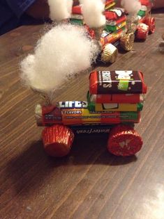 a wooden table topped with lots of candy and marshmallows on top of it