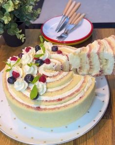 there is a cake on the table with berries and whipped cream