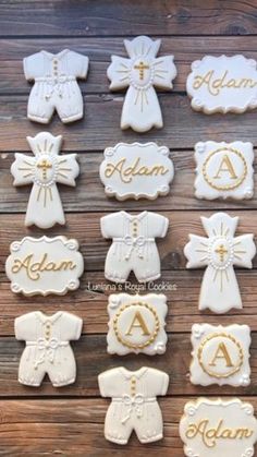 cookies decorated with baby's clothes and names are arranged on a wooden surface, including one