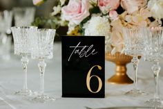 the table numbers are placed next to wine glasses