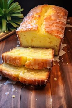 two slices of pound cake sitting on top of a wooden cutting board next to a potted plant