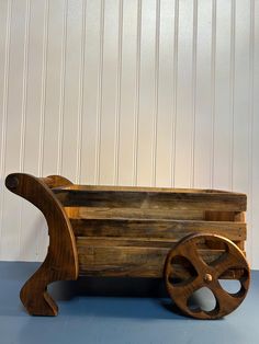 an old wooden wagon with wheels on a blue surface