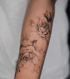 a woman's arm with black and white flowers on it