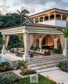 an outdoor living area with couches and tables next to a swimming pool in front of a house