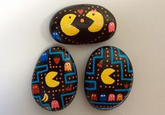 three painted rocks with pacman faces on them