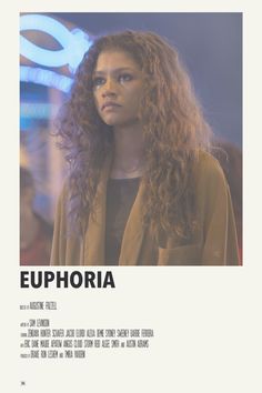 a woman with long curly hair standing in front of a sign that says euphoria