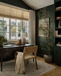 an office with green walls and wood floors, along with a large rug on the floor