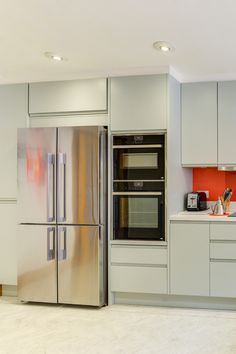 a modern kitchen with stainless steel appliances and white cabinets