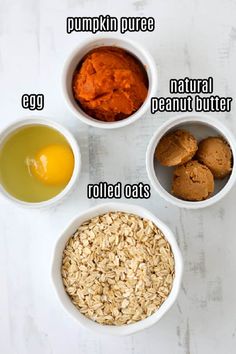 four bowls with different foods in them on a white surface, including pumpkin puree, natural peanut butter, rolled oats and an egg