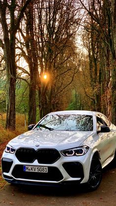 a white car parked in front of some trees