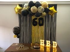 balloons and streamers are on the table in front of a birthday party backdrop that says 60