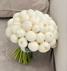 a bouquet of white flowers sitting on top of a couch