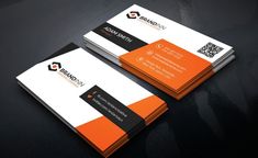 two orange and black business cards sitting on top of a table next to each other