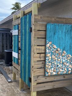 a wooden structure that has been painted with blue and white designs on the outside, along with wood planks