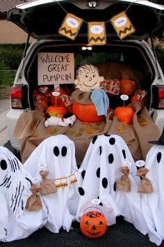 halloween decorations in the trunk of a car with pumpkins and ghost bags on it