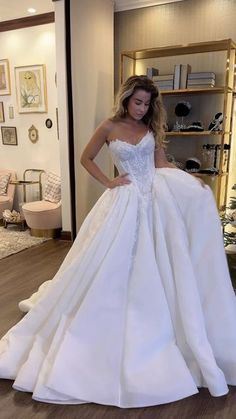 a woman in a white wedding dress posing for the camera