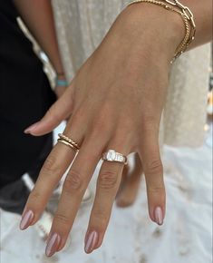 two people wearing wedding rings and bracelets with their hands on each other's fingers