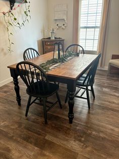 a dining room table with four chairs around it