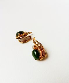 Pretty vintage clip on earrings. Faux gold casing with faux pearl and green stone. Approximately 1" tall. Lightweight. Green Clip-on Earrings For Formal Occasions, Green Clip-on Formal Earrings, Mid-century Clip-on Earrings For Formal Occasions, Mid-century Clip-on Earrings For Formal Events, Mid-century Formal Clip-on Earrings, Antique Green Clip-on Jewelry, Vintage Green Clip-on Jewelry, Retro Green Clip-on Earrings, Small Earrings Gold