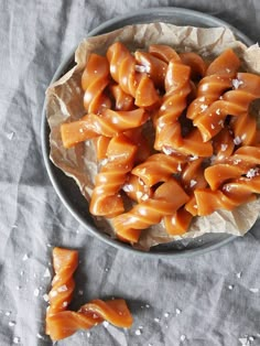 some kind of food that is in a bowl on top of a table with paper