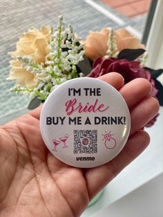 a person holding a button that says i'm the bride buy me a drink